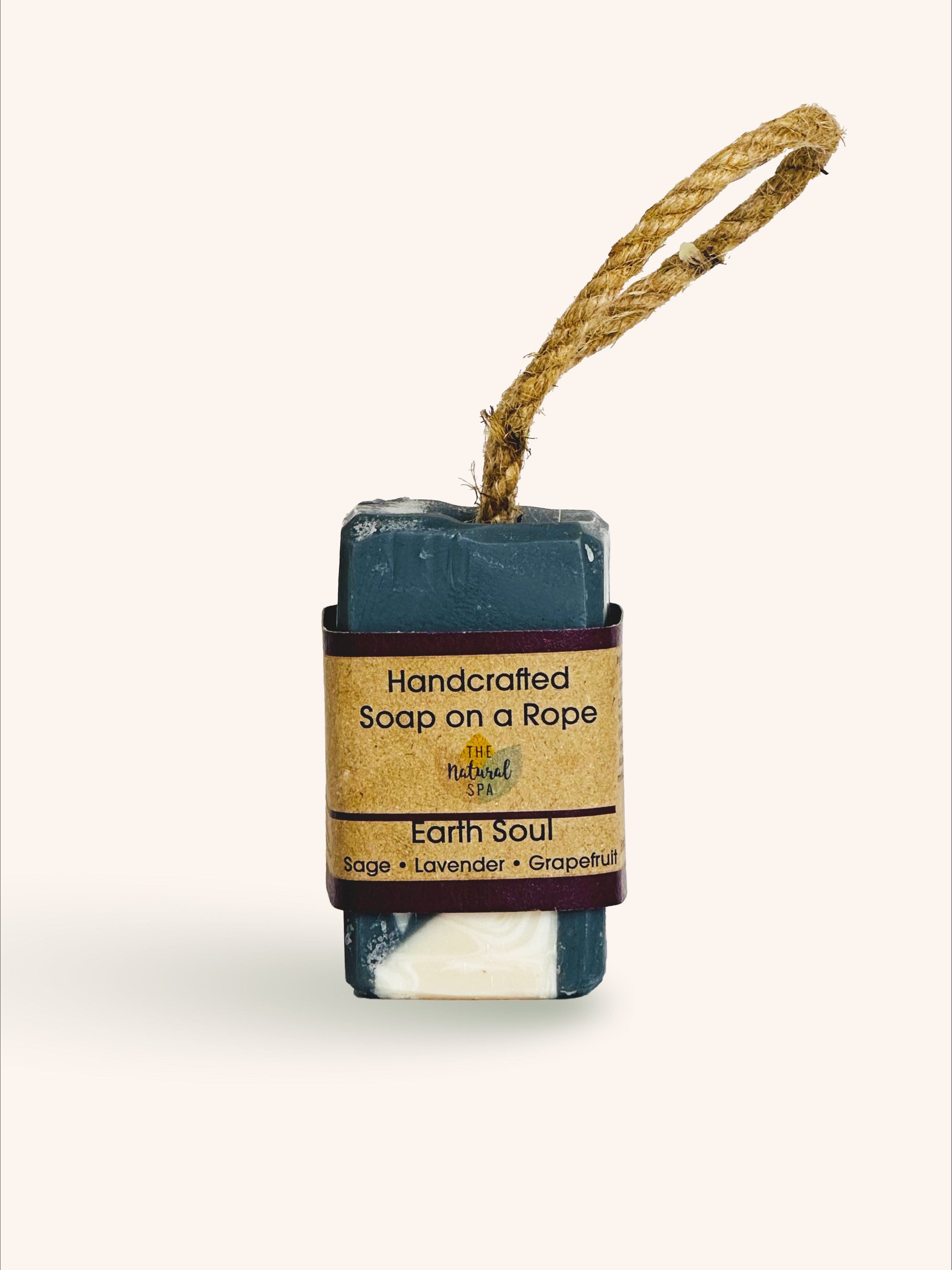 A small, blue bar of handmade soap on a rope, with a label that reads 'Earth Soul. Handcrafted Soap on a Rope.