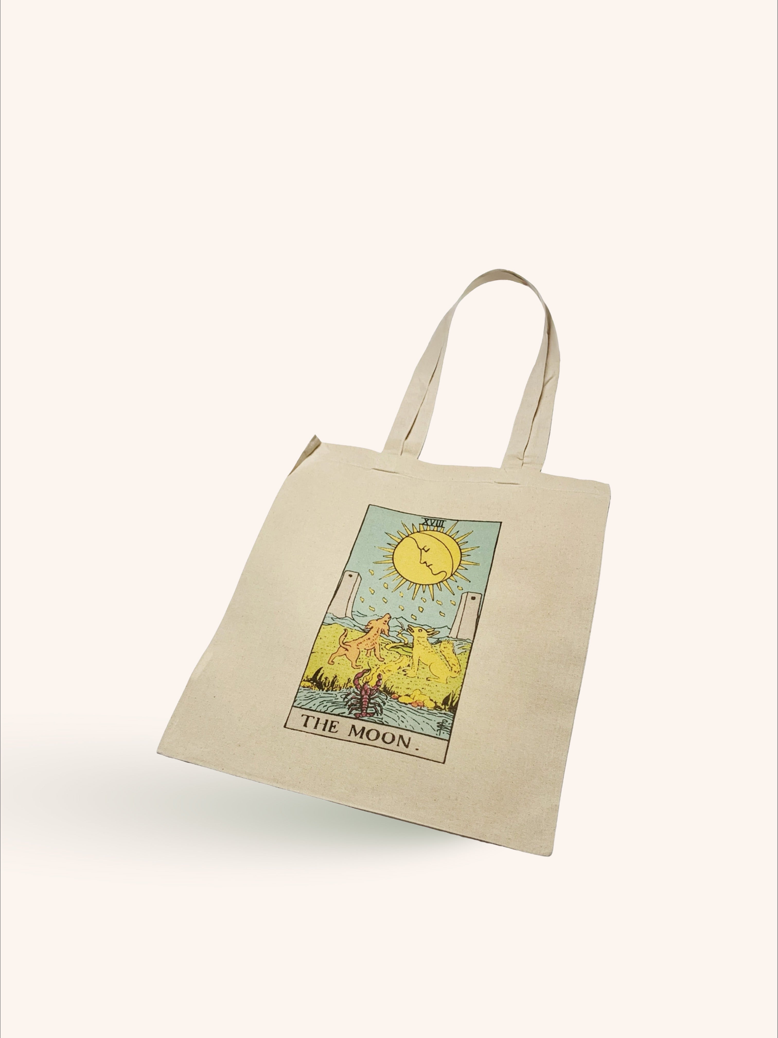 A beige tote bag with a vintage floral print in the center, displayed against a white background.