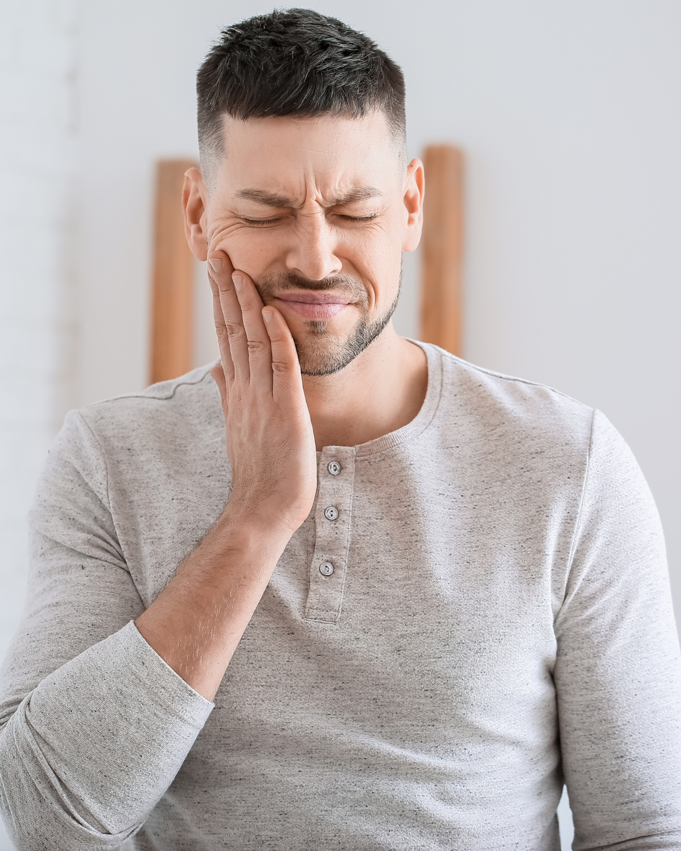 Man holding cheek in pain from toothache