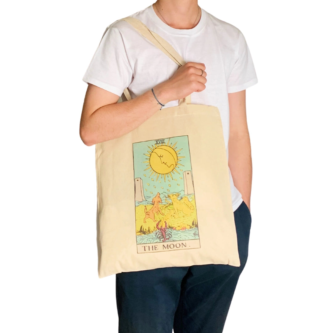 Person holding a tote bag with 'The Moon' tarot card design.
